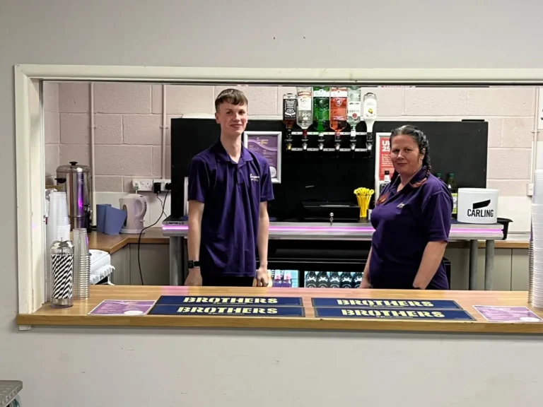 Sam and Lou stood behind the bar.